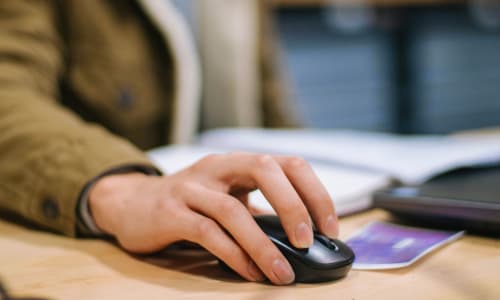 Person using a computer mouse, representing simple onboarding and no extra admin for estate agent partners